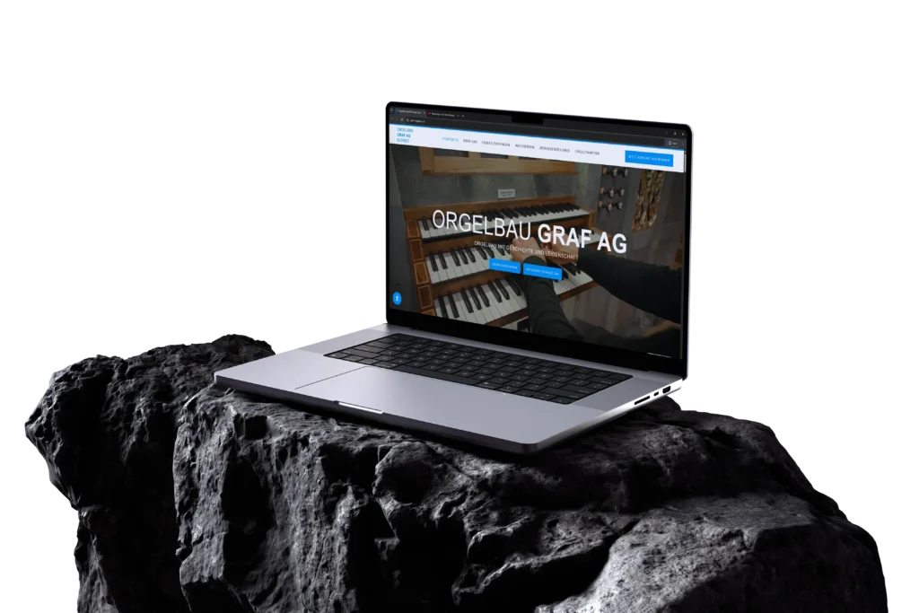 Website-Mockup von Orgelbau Graf AG: Laptop auf dunklem Stein vor schwarzem Hintergrund zeigt die Startseite mit Orgelklaviatur, blauen Akzentfarben und Navigation, Präsentation der Website im Desktop-Format.