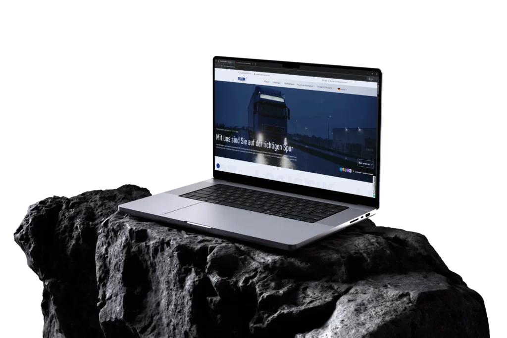 Laptop auf einem dunklen Stein mit geoeffneter Webseite eines Logistikunternehmens mit Lkw Motiv vor schwarzem Hintergrund.